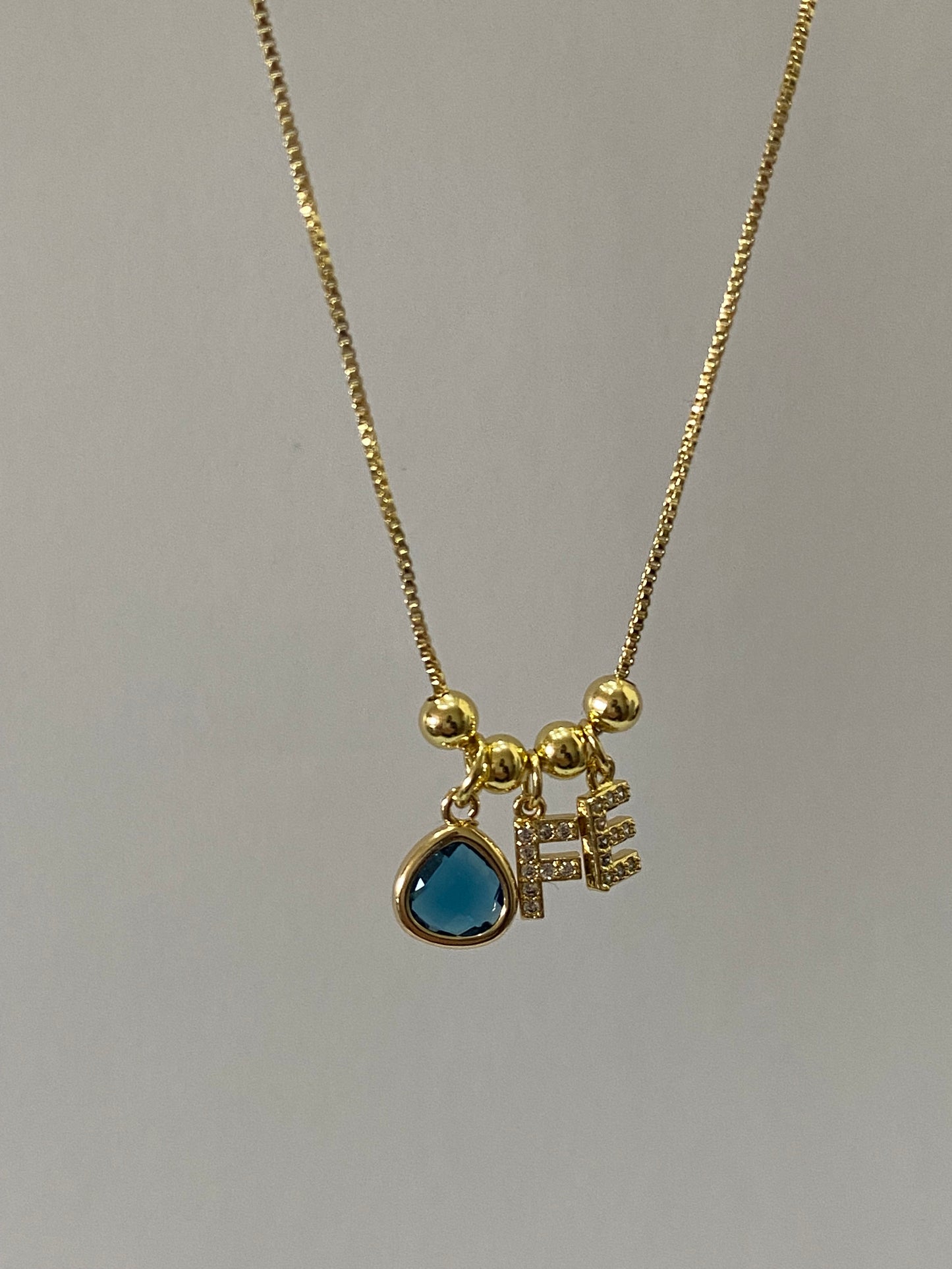 Collar fe con microcircones engastados en baño de oro gema azul